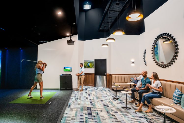 Visitors in a golf simulator lounge