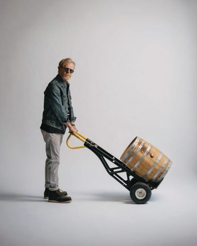 William H. Macy wheeling a barrel