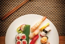 Tuna roll and assorted seasonal nigiri including shrimp, red snapper, bluefin tuna, yellowtail, octopus, scallop, amberjack, and king salmon.