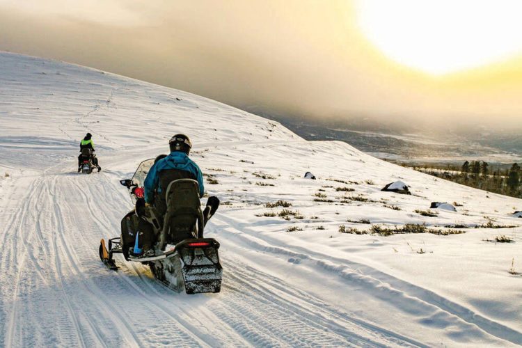 Snowmobiling on mountain trail