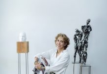 Gail Folwell sits in front of three of her sculptors