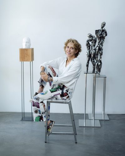 Gail Folwell sits in front of three of her sculptors 