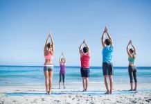 People doing yoga on the beach.