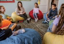 Brook Griese sits in circle on the floor with children at Judi’s House.