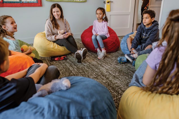 Brook Griese sits in circle on the floor with children at Judi’s House.