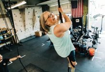 A woman climbs a rope at Axistence Athletics.
