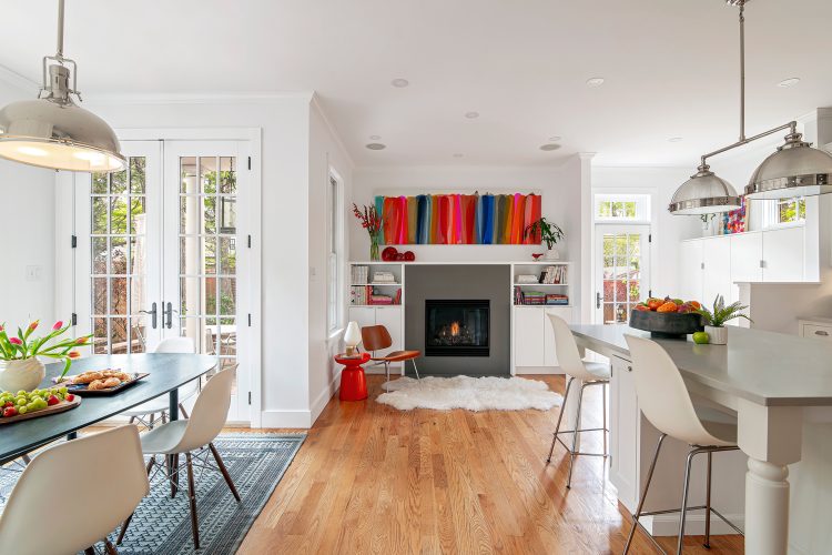View of whole kitchen area, dining area, mudroom, and fireside nook by designer Jennifer Rhode.