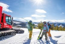 Skiers stand near a snowcat at Devil's Thumb Ranch.
