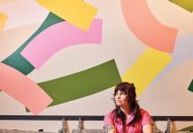 Barista Rachel Crellin sits with a cup of coffee at Huckleberry Roaster’s.