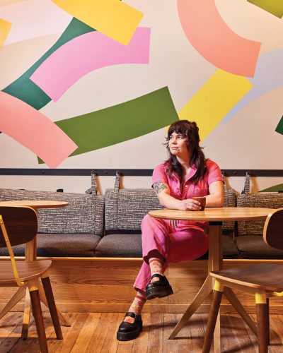 Barista Rachel Crellin sits with a cup of coffee at Huckleberry Roaster’s. 