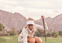 A woman golfs in Rhone clothing.