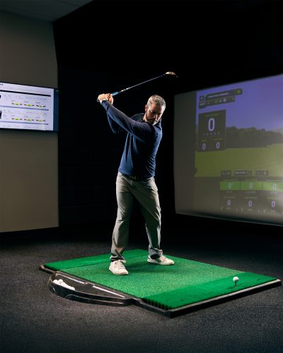 Patrick Nuber practices in a golf simulator.