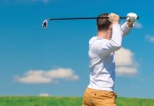 A golfer swings his golf club.