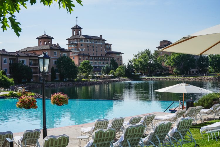 An outdoor pool with lounge chairs beckons sun bathers and swimmers alike at The Broadmoor.