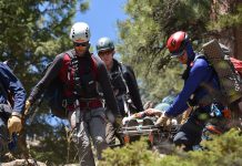 The Alpine Rescue Team carries a stretcher out of the wilderness.