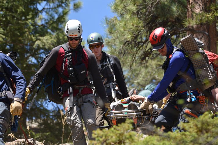 The Alpine Rescue Team carries a stretcher out of the wilderness.