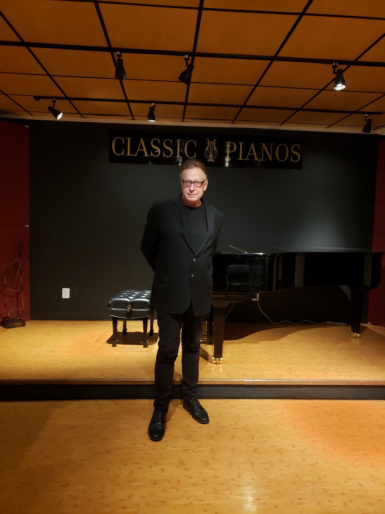 Rob Mullins in front of a stage with a piano on it.