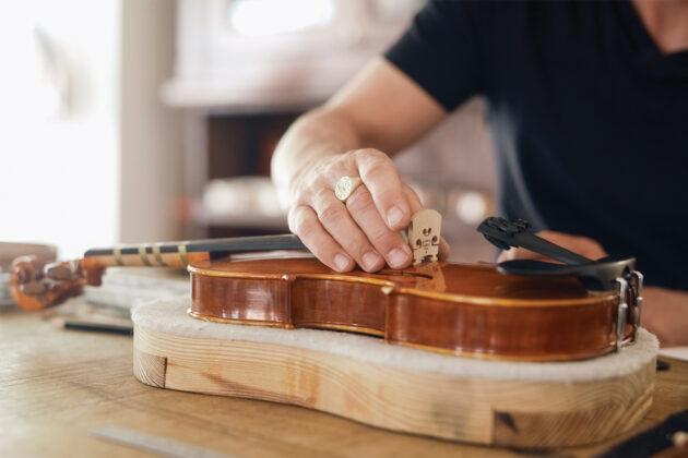 Will Scherer stringing a violin at Scherer Violin Shop.