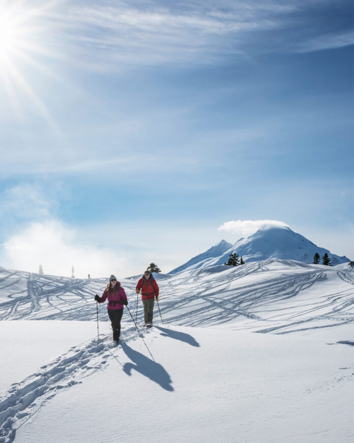 People snowshoe through the mountains using Crescent Moon Snowshoes.