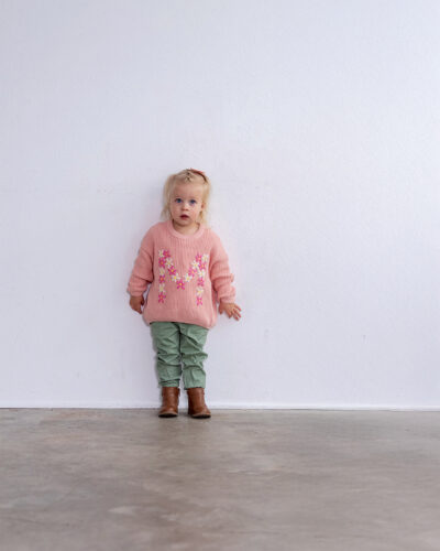 A child poses in a sweater by Ollu.