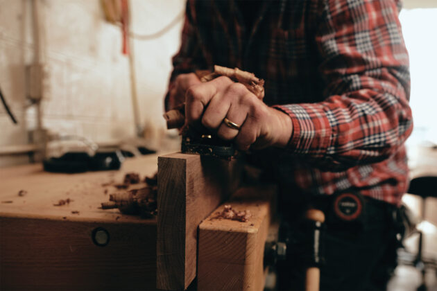 A craftsman woodworking in the studio.