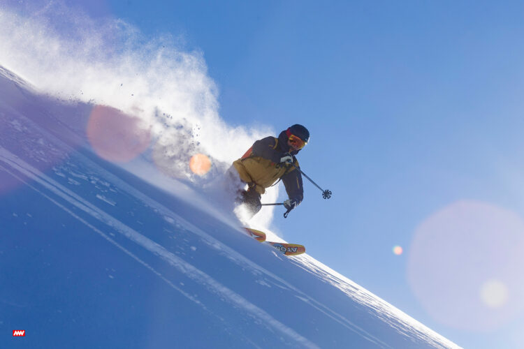 Person skiing down a mountain during heli skiing.