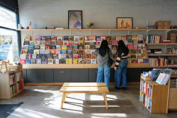 Customers explore the bookshelf at Carbon Knife Co. 