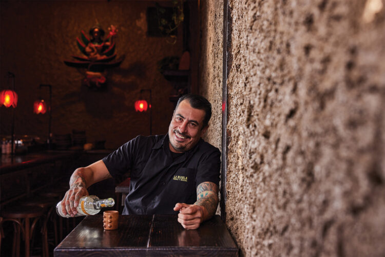 Chef José Avila poses at a table in Malinche Audiobar.