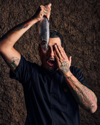 Chef José Avila playfully poses with a whole fish.