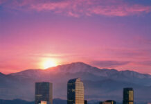 A Love Letter to Living in Colorado The Denver skyline against the mountains at sundown.