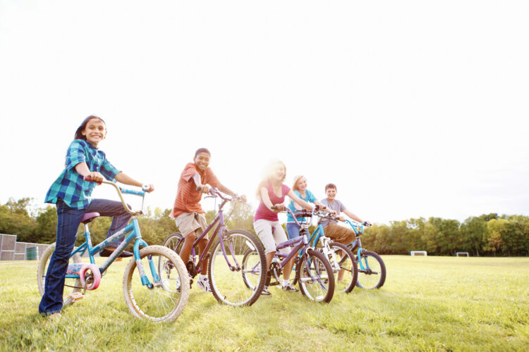 Children pose on bikes.
