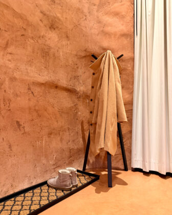 A coat hangs on a coat rack in a cave suite at Honey Rock Landing.