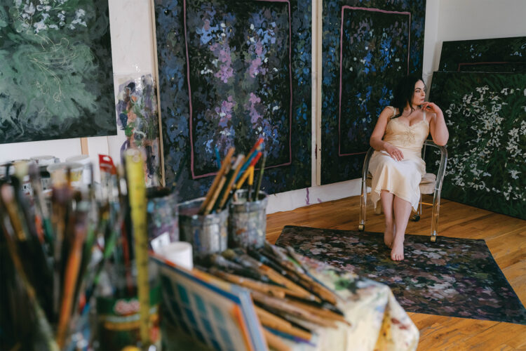 Artist, Joon Tajadod, poses among her artwork.