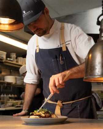 Chef garnishes a dish with micro greens from Mountain Man Micro Farms.