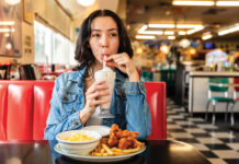 Where to Find the Best Diners in Denver Woman sips milk shake at Guther Toody's Diner.