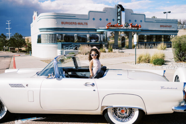 Child poses in vintage car outside Guther Toody's Diner.