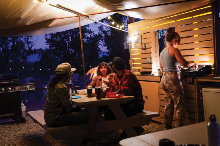People cook in the outdoor kitchen at Ramble Camp.
