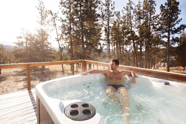 Person relaxes in hot tub at the A-frame cabin.