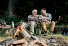 People drink coffee by a campfire.