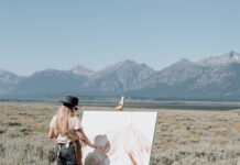 Kelly Peters paints in a field facing the Front Range mountains.