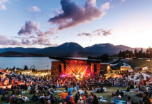 A concert takes place at Mountain Music Mondays at Dillon Amphitheater with views of the mountains and reservoir.