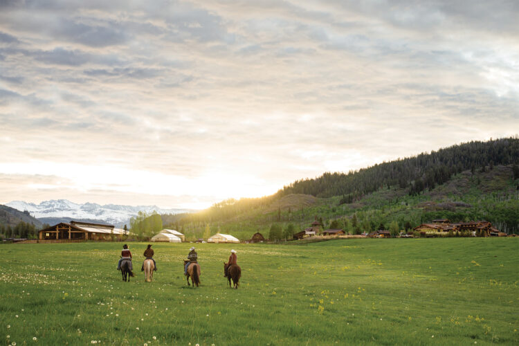 People ride horses at The Home Ranch.