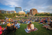 People lounge on the grass at a Denver Park.
