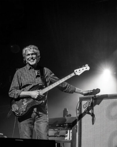 Keith Moseley, from The String Cheese Incident, smiles with his guitar on stage.