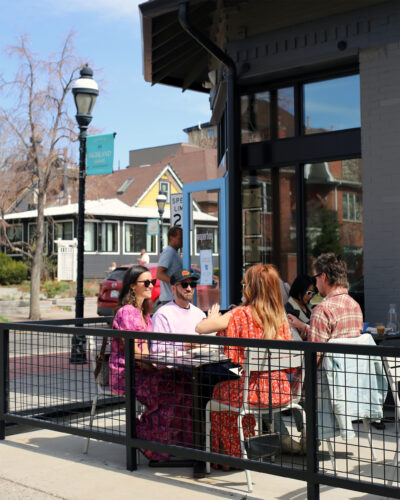 People eat on the patio at Paperboy Denver.