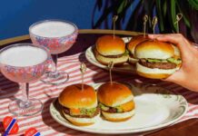 Stars, Spice and Social Darts at Flight Club Denver Image showing four slider style burgers as well as two pink cocktails on an American Flag themed place setting.