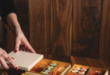 Woman assembles sushi boxes from Uchiko.