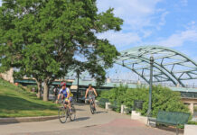 People bike under a bridge in Denver.