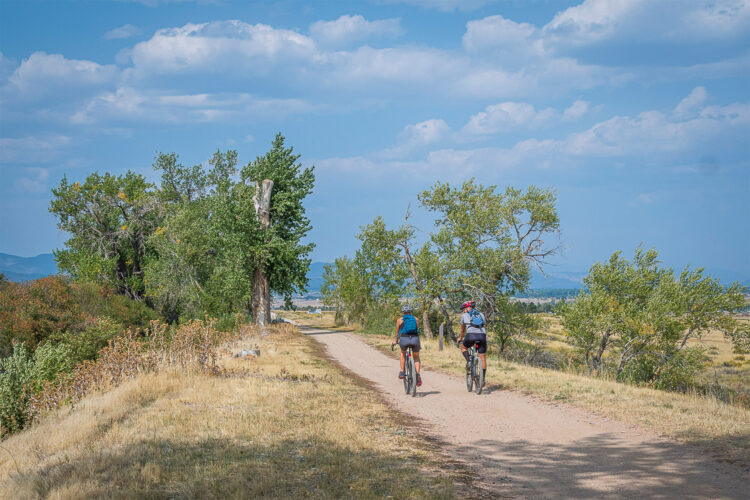 People bike on open space bike path in Denver.