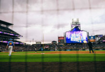 Player walks across the field after a home run at Coors Field.